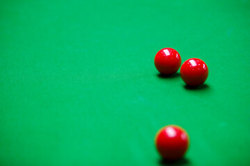 Close-up of red snooker balls on a green table, ready for the next shot. A game of precision, strategy, and skill in a professional billiards setting.