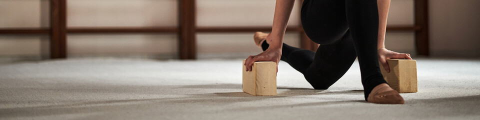 Caucasian teenage girl practicing rhythmic gymnastics training, kneeling on floor and balancing on...