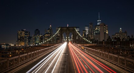 Fototapeta premium Night view of the Brooklyn Bridge with city lights and blurred car trails.
