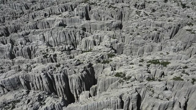 Weathered limestone cliffs display complex karst formations and geological erosion patterns on the Tresteni vrh plateau, aerial view