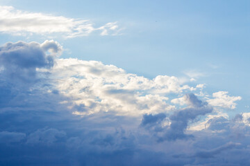 white cumulus clouds on a blue sky. beautiful nature background in afternoon light. sunny weather...
