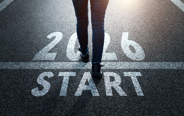 Woman standing on asphalt road with the text 2026. Concept of new year, fresh beginning
