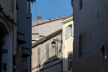 Sunlit old windows and pastel shutters in a narrow alley. Authentic southern architecture in Le Panier, Marseille, France, Marseilles