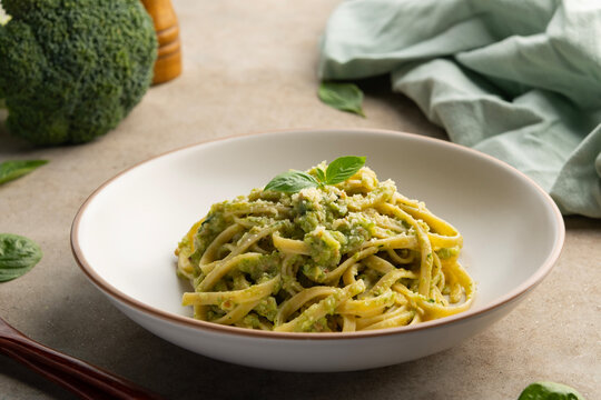 Vegetarian vegan green pasta, Fettuccine pasta with broccoli pesto sauce and cheese in white plate.Healthy food. - Powered by Adobe