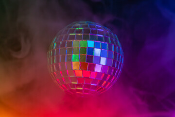 Image of a disco ball against a vibrant gradient backdrop purple to orange, reflecting lights in a festive or celebratory atmosphere, commonly symbolizing fun and lively gatherings