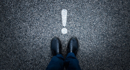 Man standing on asphalt road with exclamation point