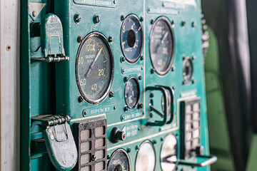 Vintage aircraft cockpit instrument panel, densely populated with gauges, switches, and buttons...