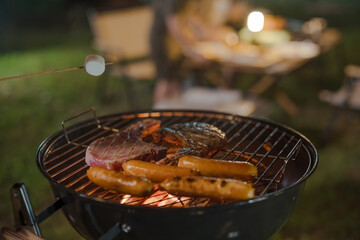 A grill with hot coals and meat on it