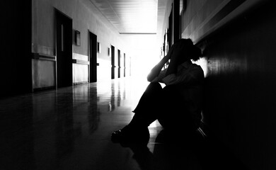 Sad woman sitting on the corridor floor