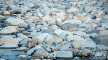 River pebbles with different textures close-up. Stone background.Pebbles or river stone background with vintage filter.