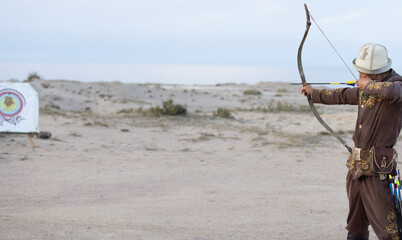 a nomadic Kyrgyz hunter shot arrow by his bow.  Kyrgyzstani is nomads in central asia