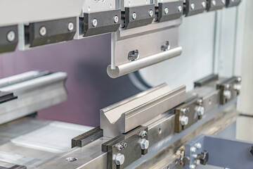 Industrial setting with mechanical components, metallic structures, frames, hinges, machinery, manufacturing or assembly equipment, grayscale color palette, indoor lighting, diffused light sources