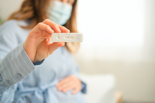 Expecting mother analyzing molecular diagnostic test outcome. Important infection control measure in prenatal care routine.