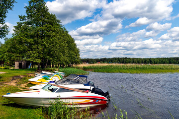 Boats and launches are moored near the shore of the magnificent Lake Lilaste for fishing and lake...