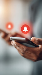 Notification alert concept with hand holding smartphone and red bell icon
