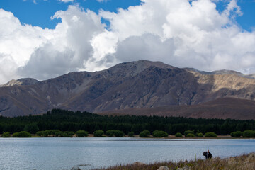 Tranquil Lake Surrounded by Mountains and Clouds
