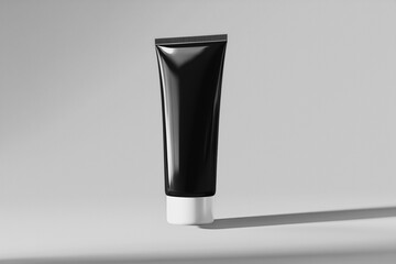 Black cosmetic tube on gray background with shadow