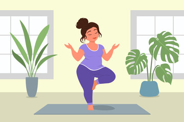 Woman doing yoga in room. Girl standing on one leg in relaxation meditation pose on mat with eyes closed