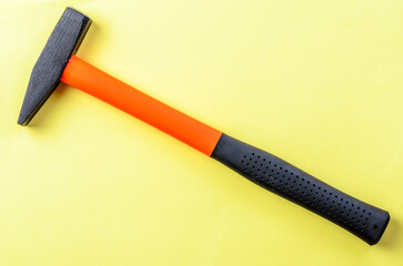 Hammer tool on bright yellow background isolated closeup sharp image