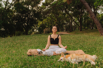 Fit sporty mindful young woman meditating, doing yoga and breathing exercises with eyes closed,...
