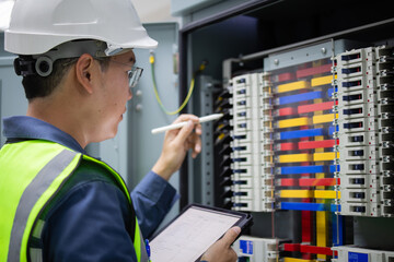 Engineer performs inspection on electrical load center unit using tablet and pen to ensure safety...