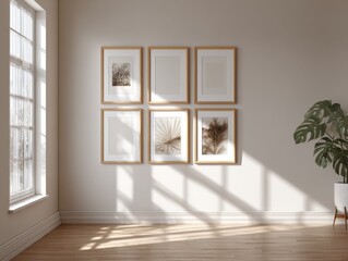 A white wall with a window and a plant. There are six framed pictures on the wall. The pictures are all different sizes and are arranged in a row