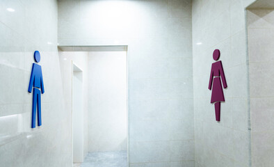 The gender signs for public restrooms are on the wall