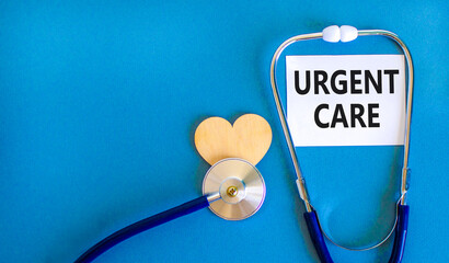 Urgent care symbol. Concept words Urgent care on beautiful white card. Wooden heart and stethoscope. Beautiful blue background. Medical healthy lifestyle urgent care concept.