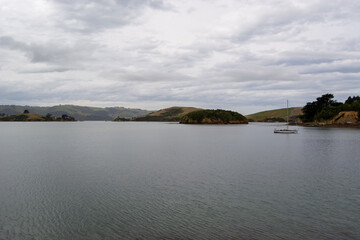 Serene Landscape with Sailboat on Calm Water