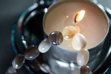 An earthy agate bead bracelet coiled within a heart-shaped mirrored box, symbolizing self-love,...