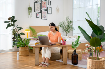 Young asian university woman doing homework at home
