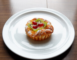 A Danish pastry topped with sliced kiwi and grapes from the Sunday market.