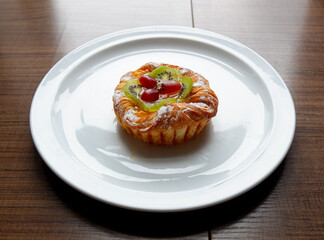 A Danish pastry topped with sliced kiwi and grapes from the Sunday market.