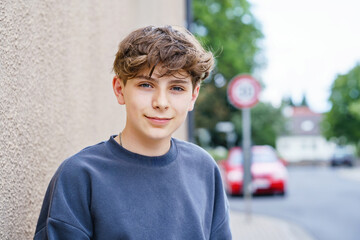Portrait of smiling teenage schoolboy looking at camera. Happy teenage boy, smiling confidently into the camera. Portrait of a school kid enjoying student life. Education and youth lifestyle concept.