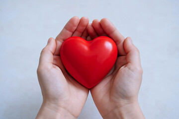 Obraz premium Cupped Hands Holding a Red Heart