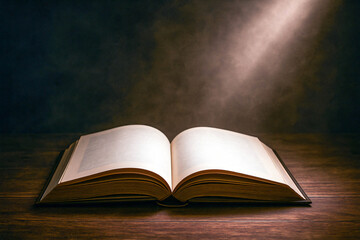 Open Book on Wooden Table with Light Beam from Above