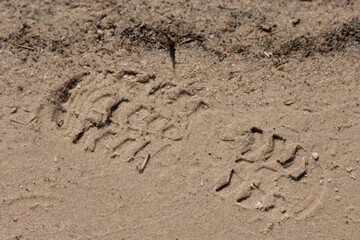 Texture of sand and earth, traces of human feet and shoes
