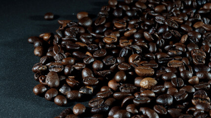 close up of many coffee beans on black background