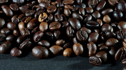 close up of many coffee beans on black background