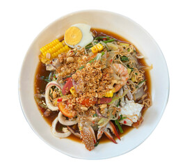 A spicy Thai-style papaya salad with mixed seafood, instant noodles, boiled egg, and corn, topped with crispy fried garlic. Served on a white plate with transparent background.