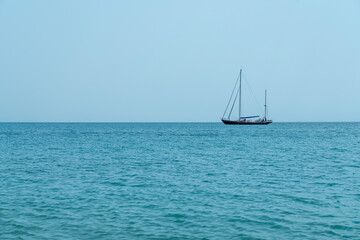 Sailboat Gliding Across Calm Waters on a Sunny Day by the Coast