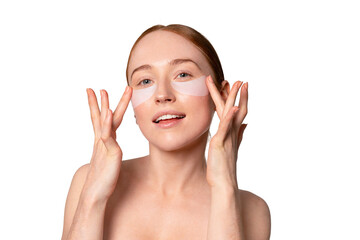 Woman applying under-eye patches while smiling, showcasing a skincare routine focused on hydration...