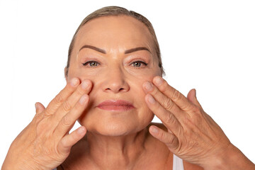 Woman applying skincare treatment on her face in a bright setting