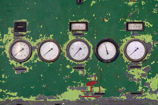 weathered control panel with analog gauges and pressure meters on a peeling green surface. Industrial retro composition, perfect for themes related to machinery, engineering, and vintage technology. - Powered by Adobe