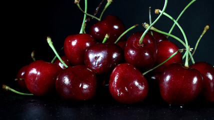 close up of group of red cherries on black background