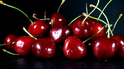 close up of group of red cherries on black background