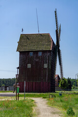 Wooden post windmill set against a meadow and blue sky on a sunny day. A historic structure...