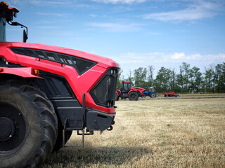 Several large modern red tractors standing in a field.