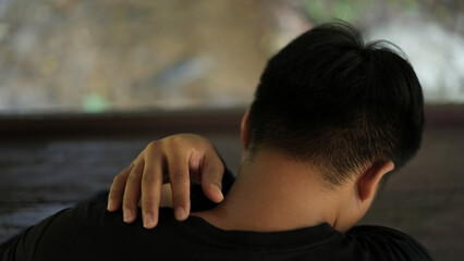A young asian man athlete with lower backache, neck pain and shoulder pain, injury or strained...