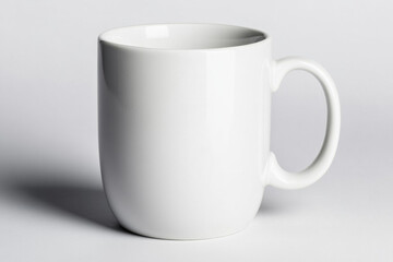 Obraz premium Close-up of a white ceramic coffee mug placed on a clean white background, with no logos or designs. 
